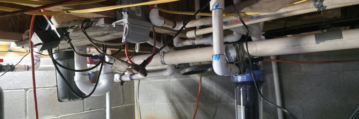 Extension cords and electrical connections installed near basement plumbing